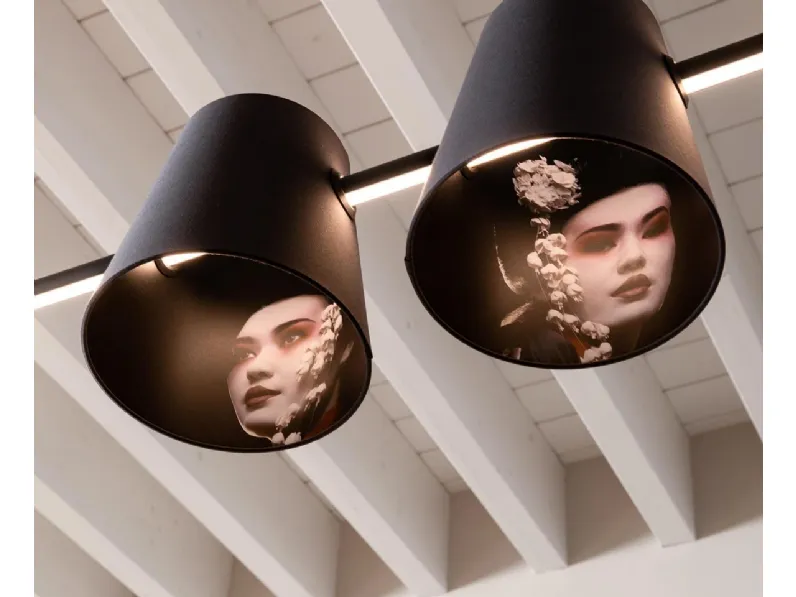 Lampada a sospensione costituita da una lunga e minimale barra di luce a led che trafigge un paralume in tessuto Cupido di Karman