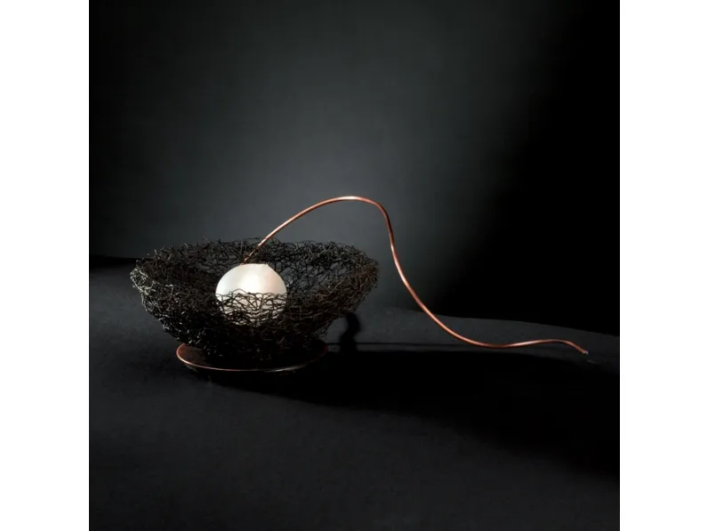 Lampada da tavolo realizzata in rete metallica con un uovo in vetro soffiato appoggiato all'interno Nido di Icone