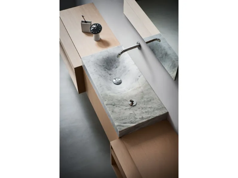 Lavabo in marmo dalla forma asimmetrica che definisce un comodo piano d’appoggio 815 di Agape