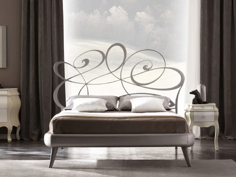 Letto con testiera in ferro,  giroletto imbottito in tessuto e piedi in legno decoratoNoemi di Cortezari