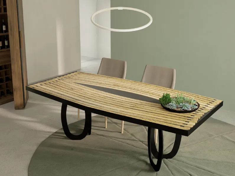 Tavolo Hypnotic con top costituito dall’accostamento di più doghe ricurve intervallate da inserti di resina nera e gambe composte ciascuna da due anelli ovali in ferro di Riva1920