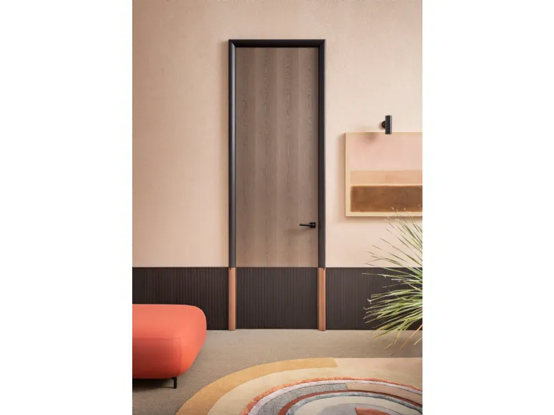 Porta per interni battente in legno dove la parte inferiore è caratterizzata da una superficie con intagli geometrici Ying di Lualdi