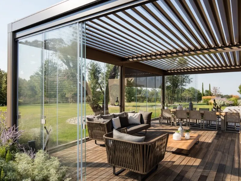 Pergola bioclimatica in alluminio con lame frangisole orientabili e pareti scorrevoli in vetro trasparente Opera di Pratic